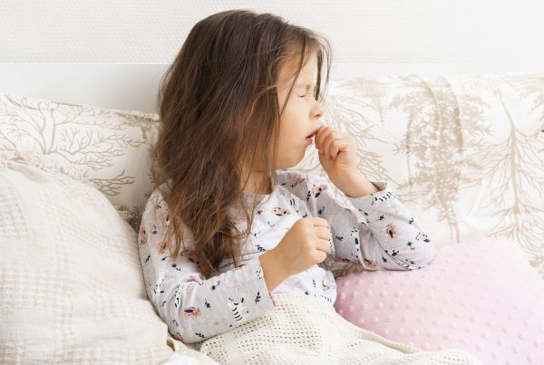 Niña en la cama, afectada por la tos