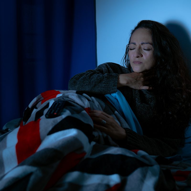 Mujer en la cama, afectada por la tos
